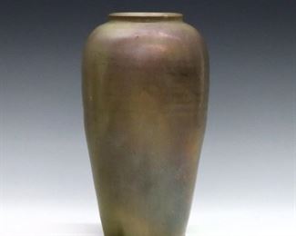 An early 20th century Pewabic Art Pottery vase.  Tapered form with rounded shoulders and iridescent glaze in shades of Pale Green and Purple.  Faint circular impressed mark obscured by glaze.  Some crazing and surface wear, several flakes to glaze at foot.  9" high.  ESTIMATE $800-1,200