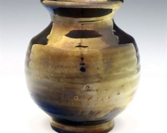 An early 20th century Pewabic Art Pottery vase. Round form with textured body, flared rim and iridescent glaze in shades of Blue and Purple. Impressed mark partially obscured by glaze. Minor surface wear. 5" high. ESTIMATE $300-400