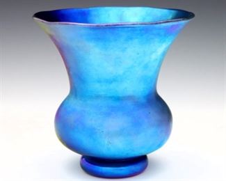 An early 20th century Steuben Blue Aurene glass vase. Shape #2533, footed bulbous form with trumpet neck and scalloped rim. Polished pontil with etched "Steuben" signature. Minor surface wear and light scratches. 5" high. ESTIMATE $300-400