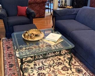Navy blue sofa, chair, and ottoman; glass top coffee table