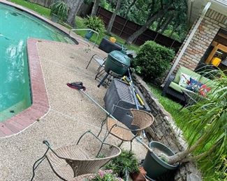 Plants, chairs, and a green egg by the pool.