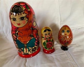 Two complete nesting dolls and one egg figurine