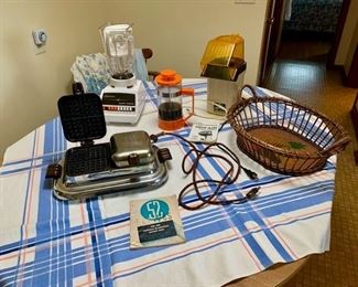 Vintage GE Waffle Iron with original recipe book, Oster Blender, French Press, air popcorn maker, wicker basket, vintage aprons, table cloth