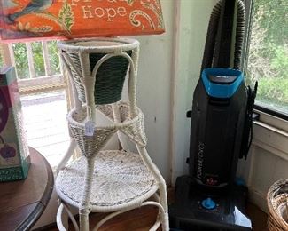 Wicker plant stand and Bissell vacuum. 