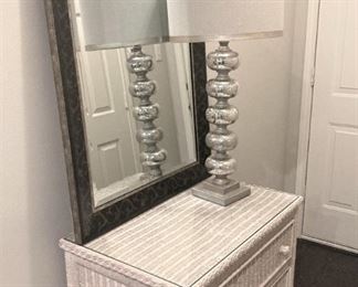 White wicker 3-drawer chest; silver lamp; large mirror
