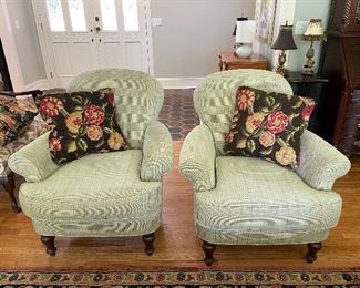 Armed club chairs, floral pillows, small decorative lamps.