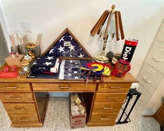 oak desk, several American flags, metal file cabinet