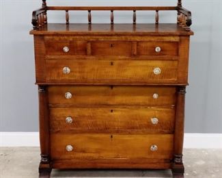 A 19th century American Empire Transitional chest.  Curly Maple construction with galleried back, three short drawers over one long drawer and three additional long drawers, flanked by turned columns on scroll feet.  Older refinishing with minor wear, some older repairs, replaced knobs.  19 1/2 x 43 1/2 x 53 1/2" high overall.  ESTIMATE $300-400
