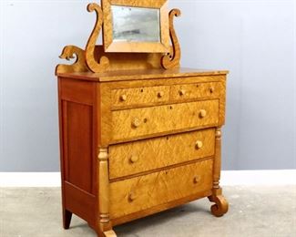 An early 19th century American Empire Transitional chest.  Birdseye and Soft Maple construction with a scrolled backsplash and attached swing mirror over a base with two short and three long graduated drawers flanked by turned pilasters on scroll feet.  Older refinishing with wear, replaced knobs.  44 x 21 x 64" high overall.  ESTIMATE $200-300