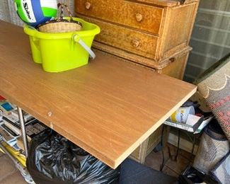 table and dresser, misc cleaning supplies, books, and baskets