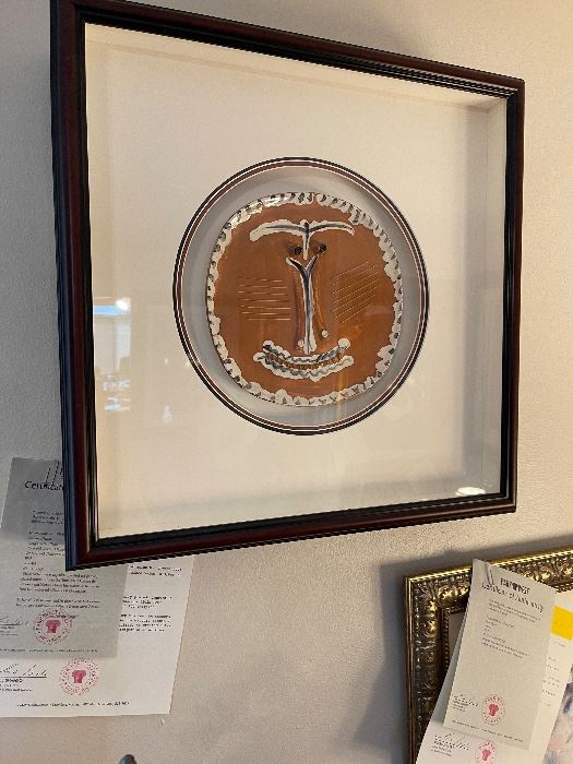 PABLO PICASSO: "Visage au Nez Pince" (Face with Pinched/Pursed Nose) - 1959.  10.25" x 10". White earthenware clay plate, painted and partially glazed.  Imprinted with the "Empreinte Originale de Picasso"  and "Madoura Plein Feu" stamps on the verso.  From the numbered edition of 100 examples.  In July of 1946, Picasso and his friend Louis Fort visited the potters exhibition in Vallauris, France.  Here Picasso saw the Madoura ceramics display and was invited to see the workshop.  Inspired, he created a few pieces that day and returned a year later in anticipation of working again.  *More information available upon request and all information is based on the Certificate of Authenticity issued by Park West Gallery at the time of sale:  12/24/2007.  