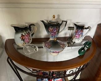 A Hand-Painted Nippon Service adorns this demi-lune table in the basement area.  