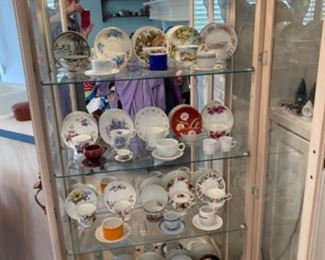 Lighted curio filled with tea cup collection from around the world.