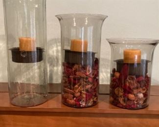 Beautiful candle containers fill with seasonal decorations.