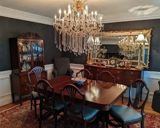 Dining room suite with vintage 1940's mahogany china cabinet, sideboard, dining table and set of six matching chairs. Wonderful 15-light Maria Theresa crystal chandelier,  huge 6' x 3 1/2' long gilt wood "tree branch" beveled glass wall mirror, pair of brass candlestick lamps,  pair of vintage marble/brass 5-light candelabras and French bronze clock, all atop a stunning, vintage hand-woven Persian Heriz.