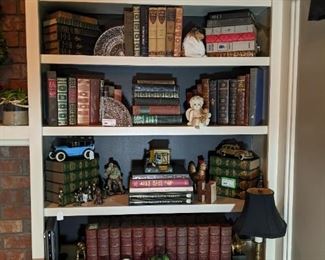 One of two bookshelves filled with old books, cast iron toys, Waterford bookends, sandcast dogs, etc.
