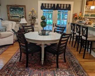 Round, farmhouse-style painted wood breakfast able, with set/4 wood/upholstered side chairs, atop a yummy hand-woven Persian Heriz rug.