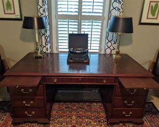 Vintage mahogany 7-drawer desk, with tooled leather top, brass pulls and double pull-out slides. 