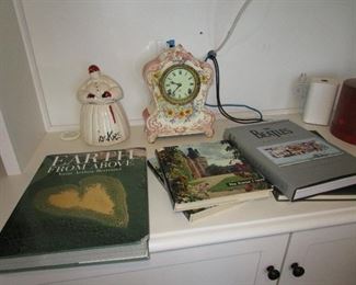 Antique clock and cookie jar with books.