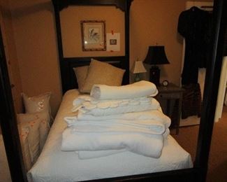 4 poster twin bed. Many blankets and linens.