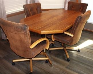 Solid oak dining table with distressed leather, rocker, swivel chairs.