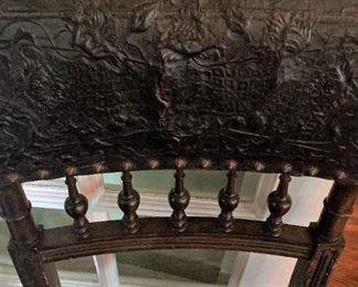 Two of four leather chairs with brass atop the back