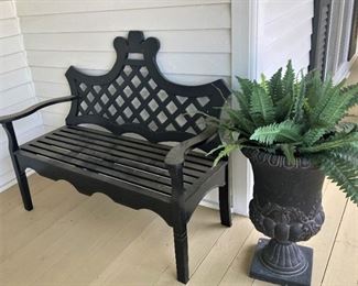 One of two black benches and planters on the front porch.