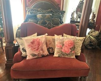 Red velvet settee; decorative pillows
