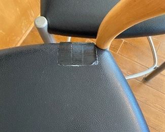 Black leather.. Each chair has a patch in the same place from cat claws. Easy to replace. 