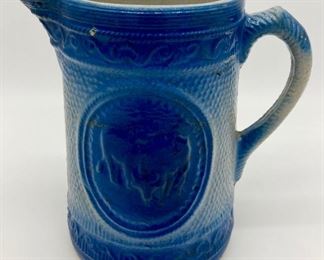 Blue and white cow themed pottery pitcher