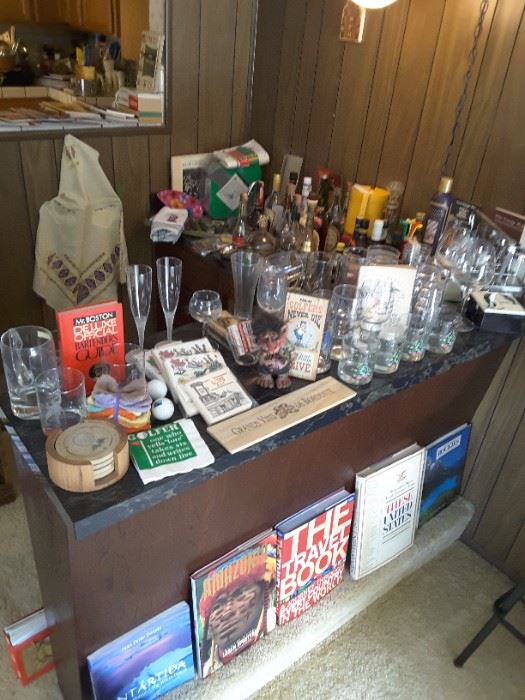 Vintage Bar Collectibles in the Family Room, Glassware, Beverage Mixing Recipe Books, Travel Books below, Vintage Bar Stools, 2, Tall, Short Glasses, Empty Liquor Bottles for Vintage Labels. Aprons, Napkins, Cutting Board, Knives, Toothpick Holders, Shot Glasses and More.