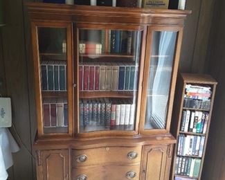 Small Short Glass Breakfront with 3 Lower Shelves and 2 Side Drawers. Historical Books on Top. 5 Shelf Media Cabinet on Swivel turns around.