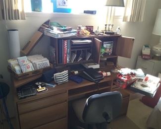 Office Desk with various Office Collectibles. Small Office Chair on Wheels. Various Greeting Cards. Christmas Collectibles and Office Lamp. World Chart Compass Map.