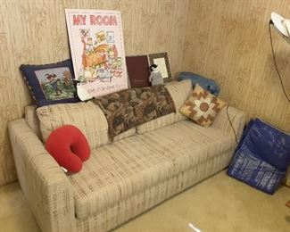 Sleeper Fabric Couch. Collection of Decorative Items, Golf Pillow, Red Neck Pillow, Safari Fringe, Leather Pillow. My Room Poster. Retirement Albums. Exercise Floor Blue Mat. Blue Sleeping Bag.