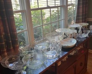 glass serveware bowls, cake trays, platters sitting on top of buffet