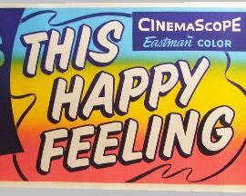 2531   1958 “This Happy Feeling” Balcony Banner/Poster. With Debbie Reynolds. 24” X 82” Cond: Right hand side has a linen tape repair with some creases & small paper loss at the bottom.