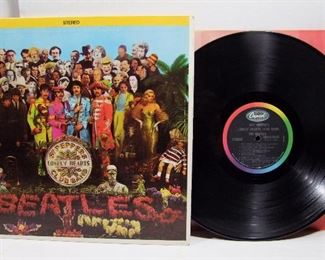 2564   Capitol SMAS 2653 (LP), June 2, 1967 “Sgt. Pepper’s Lonely Hearts Club Band” Stereo.  Cond: Record shows very light play, Cover spine has minor wear at bottom corner, cover shine at 95% with some minor wear on back, all corners have minor bumps with tiny crease in upper left corner of front. Orig. cut-out insert present & near mint. Overall 8 Rating.