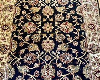 Oriental Rug at the entryway, black, tan, cream, burgundy with fringe trim.