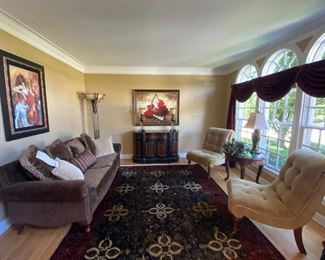 Stunning Living Room with a (never sat in) Sofa by Huntington House, 2 Armless Occasional Chairs with scrolled top in Tan Microsuede, Exceptional Wall Art by Rena and Sotskova, Beautiful Custom Rug , Carved Mahogany Lamp Table with Table Lamp and Floor Torchiere Lamp.  Highlight piece is the Seven Seas Credenza by Hooker with 2 Buffet Style Lamps.
