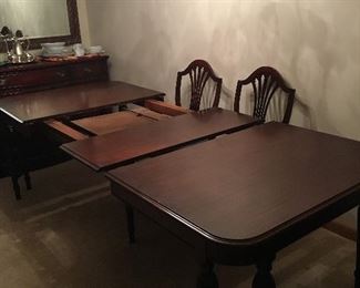 Mahogany dining room table, 5 armless chairs, one Captain’s chair, pads, 2 leaves