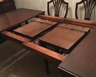 Mahogany dining room table, 5 armless chairs, one Captain’s chair, pads, 2 leaves