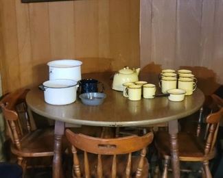 Dining table.   Enamel cookware , teapot and mugs 