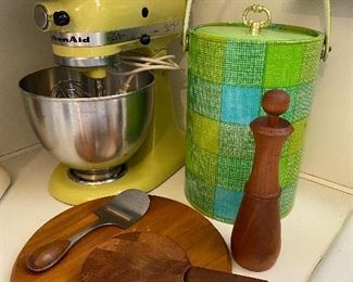 Vintage yellow KitchenAid mixer with attachments, midcentury ice bucket and Dansk items.