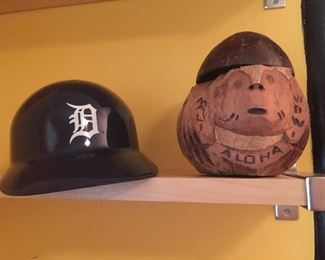 A Detroit Tigers helmet with Chevy logo on back and a carved coconut to hold a drink. 