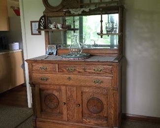 An unusual oak buffet in great condition features two mirrors with plenty of display space and room to store items out of view. 