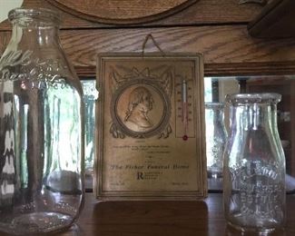 Historic pieces from Albion are two milk bottles and an advertising collectible from Fisher Funeral Home. 
