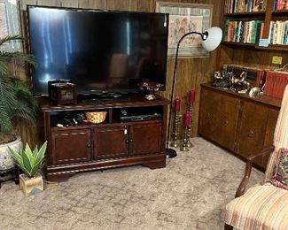 Large flat screen, DVD player and heavy wooden stand, brass candle holders, books and Compton yearbooks