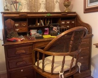 roll-top desk with rolling, cane-back desk chair