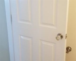 Updated solid wood interior doors with clear Lucite knobs throughout