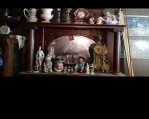 beautiful oak fireplace surround with collectibles on shelf and gorgeous gilt antique clock